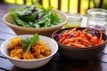 a bowl of raw vegetables next to a plate of fried food