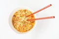 A bowl with ready ramen and wooden sticks on white background, top view. Royalty Free Stock Photo