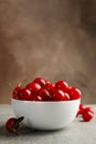 Bowl with red cherry on gray table Royalty Free Stock Photo