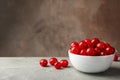 Bowl with red cherry on gray table space for text Royalty Free Stock Photo