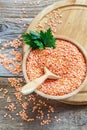Bowl with red lentils,spoon and a sprig of parsley.