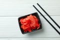 Bowl with red pickled ginger and chopsticks on white wooden background Royalty Free Stock Photo