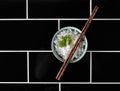 Bowl of rice on black tiled background from overhead