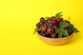 Bowl ripe grape on yellow background, space for text Royalty Free Stock Photo