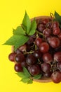 Bowl ripe grape on yellow background, top view Royalty Free Stock Photo