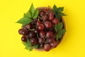 Bowl ripe grape on yellow background, top view Royalty Free Stock Photo