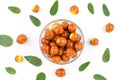 Bowl with ripe jojoba fruits on a white background. Chinese date fruit and green leaves