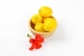 Bowl of ripe lemons and red hibiscus bloom