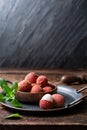 Bowl of ripe lichee fruit (Litchi chinensis) on wooden background