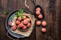 Bowl of ripe lichee fruit (Litchi chinensis) on wooden background