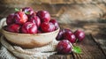 Bowl of ripe plums on table