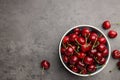 Bowl with ripe sweet cherries on grey table, flat lay. Space for text Royalty Free Stock Photo