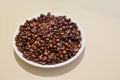 A bowl of robusta coffee beans, on beige Royalty Free Stock Photo