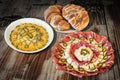 Bowl Of Russian Salad With Appetizer Savory Dish Meze And Pretzel With Sesame Croissant Snail Roll Set On Old Garden Table