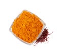 Bowl with saffron powder and dried flower stigmas on white background, top view Royalty Free Stock Photo