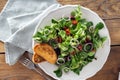 Bowl salad green mache leaves baked tomatoes on wooden table Royalty Free Stock Photo