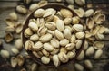 Bowl with salty pistachios in a wooden bowl on a background of shells , top view ,close up