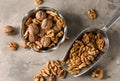 Bowl and scoop with tasty walnuts on grey table Royalty Free Stock Photo