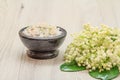 Bowl with sea salt and bouquet of lilies of the valley on wooden background