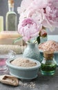 Bowl of sea salt, glass bottle of essential oil and peonies in t Royalty Free Stock Photo