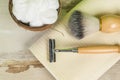 A bowl of shaving foam, a brush and a razor on a towel on a wooden table. Flat lay Royalty Free Stock Photo