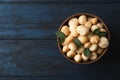Bowl with shelled organic Macadamia nuts and space for text on blue wooden background Royalty Free Stock Photo