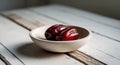 A Bowl of Shiny Red Dates on a Wooden Table. Royalty Free Stock Photo