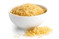 Bowl of short grain parboiled rice on white. Spilled ri