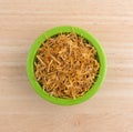 Bowl of shredded calendula flower petals on table