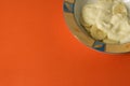 Bowl of sliced banana and yoghurt in a bowl on bright orange background - minimal, copy space Royalty Free Stock Photo