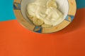 Bowl of sliced banana and yoghurt in a bowl on bright orange and Royalty Free Stock Photo