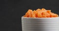 Bowl sliced carrots over black cutting board