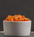 Bowl sliced carrots over black cutting board