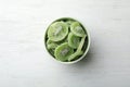 Bowl with slices of kiwi on wooden background, top view. Royalty Free Stock Photo