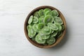 Bowl with slices of kiwi on wooden background, top view. Royalty Free Stock Photo