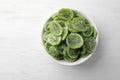 Bowl with slices of kiwi on wooden background, top view. Royalty Free Stock Photo