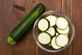 Bowl with slices of zucchini on wood from above Royalty Free Stock Photo