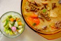 A bowl of Soto Betawi, Indonesian native traditional soup made of beef or beef offal cooked in coconut milk broth with pickles