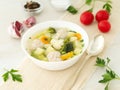 bowl of soup, a cup of broth and vegetables, meatballs made of turkey and chicken, side view