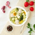 bowl of soup, a cup of broth and vegetables, meatballs made of turkey and chicken, top view