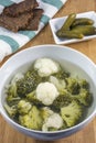 Bowl of soup with pieces of chicken, broccoli and cauliflower, bread and cucumbers on towel Royalty Free Stock Photo