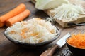 Bowl of sour cabbage, pickled sauerkraut. Fermented cabbage, coleslaw salad. Chopped cabbage on a cutting board and carrots Royalty Free Stock Photo
