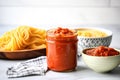 a bowl of spaghetti next to a jar of homemade tomato sauce Royalty Free Stock Photo