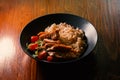 Bowl of spicy rice with chicken curry and vegetables on wooden table Royalty Free Stock Photo