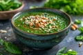 Bowl of spinach soup with chil pods and almonds