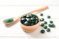 Bowl of spirulina pills and powder in spoon Royalty Free Stock Photo