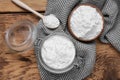 Bowl, spoon and glass jar of natural starch on wooden table, flat lay Royalty Free Stock Photo