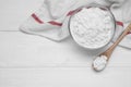 Bowl and spoon of starch on white wooden table, top view. Space for text Royalty Free Stock Photo