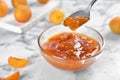 Bowl and spoon with tasty apricot jam Royalty Free Stock Photo