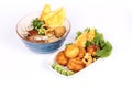 A bowl of steam pork and egg with noodle in brown sauce and a dish of deep fried minced pork in potato on white background.